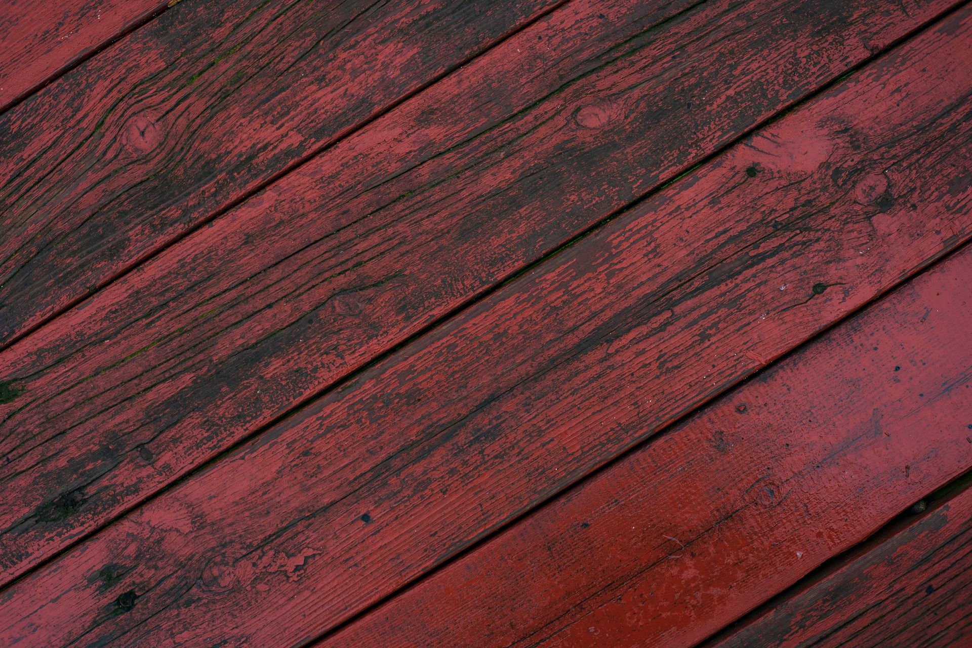 Weathered red wooden planks with dark grain